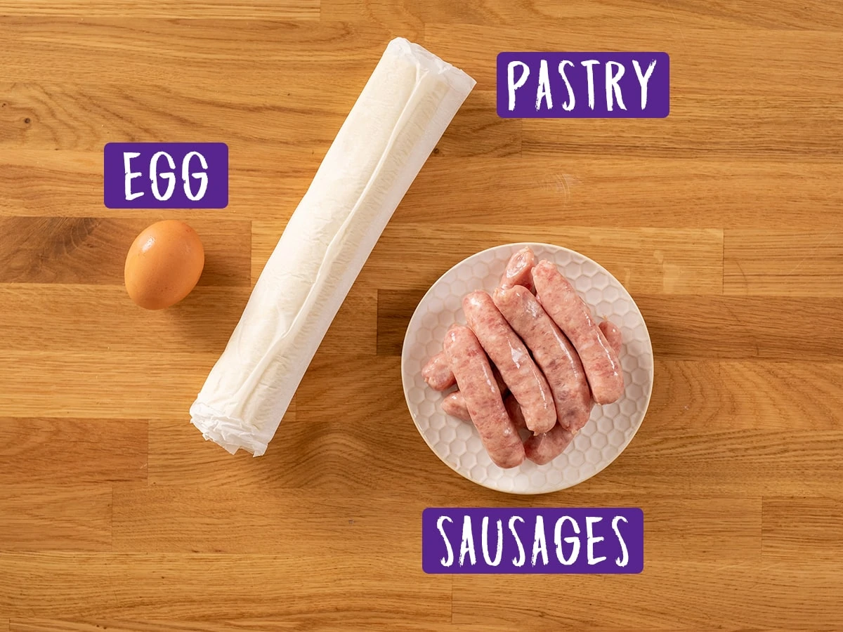 Ingredients for sausage rolls on a wooden board