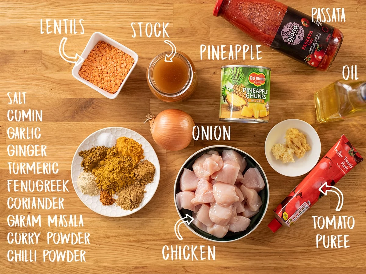 Ingredients for chicken dhansak on a wooden table