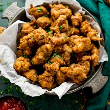 chicken pakoras in a bowl next to a green napkin