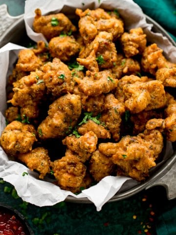 chicken pakoras in a bowl next to a green napkin