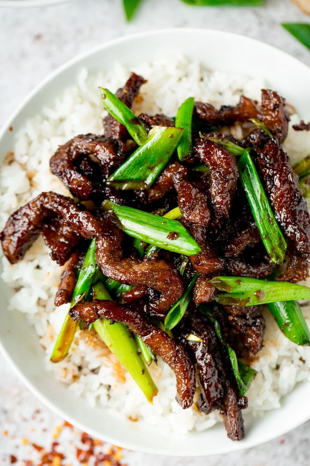 Close up overhead shot of Mongolian Beef and rice in a white bowl