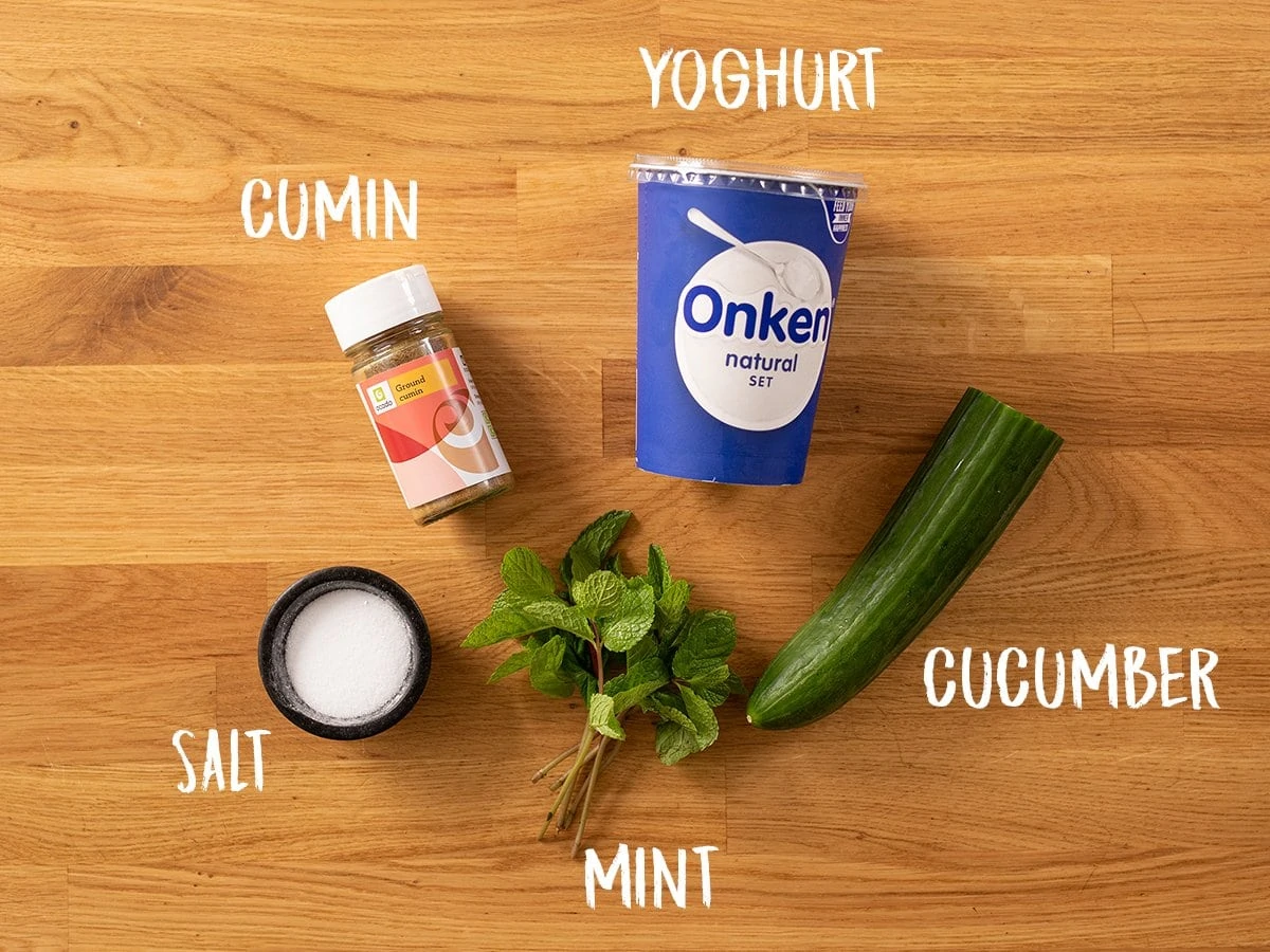 Ingredients for raita on a wooden table