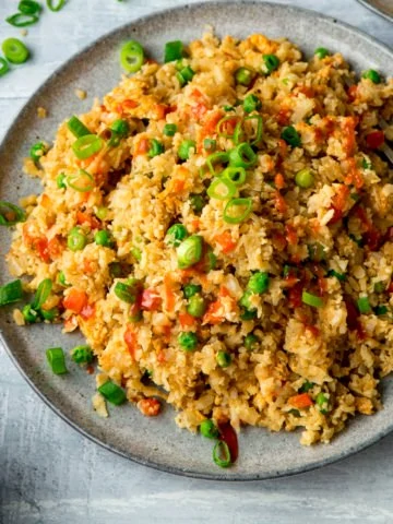 Cauliflower fried rice on a grey plate on a light background