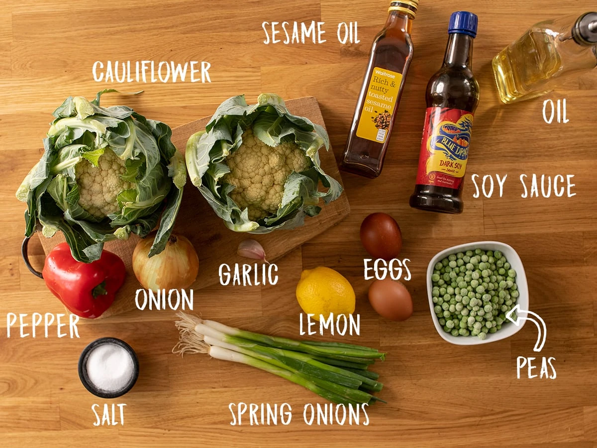 Ingredients for cauliflower fried rice on a wooden table