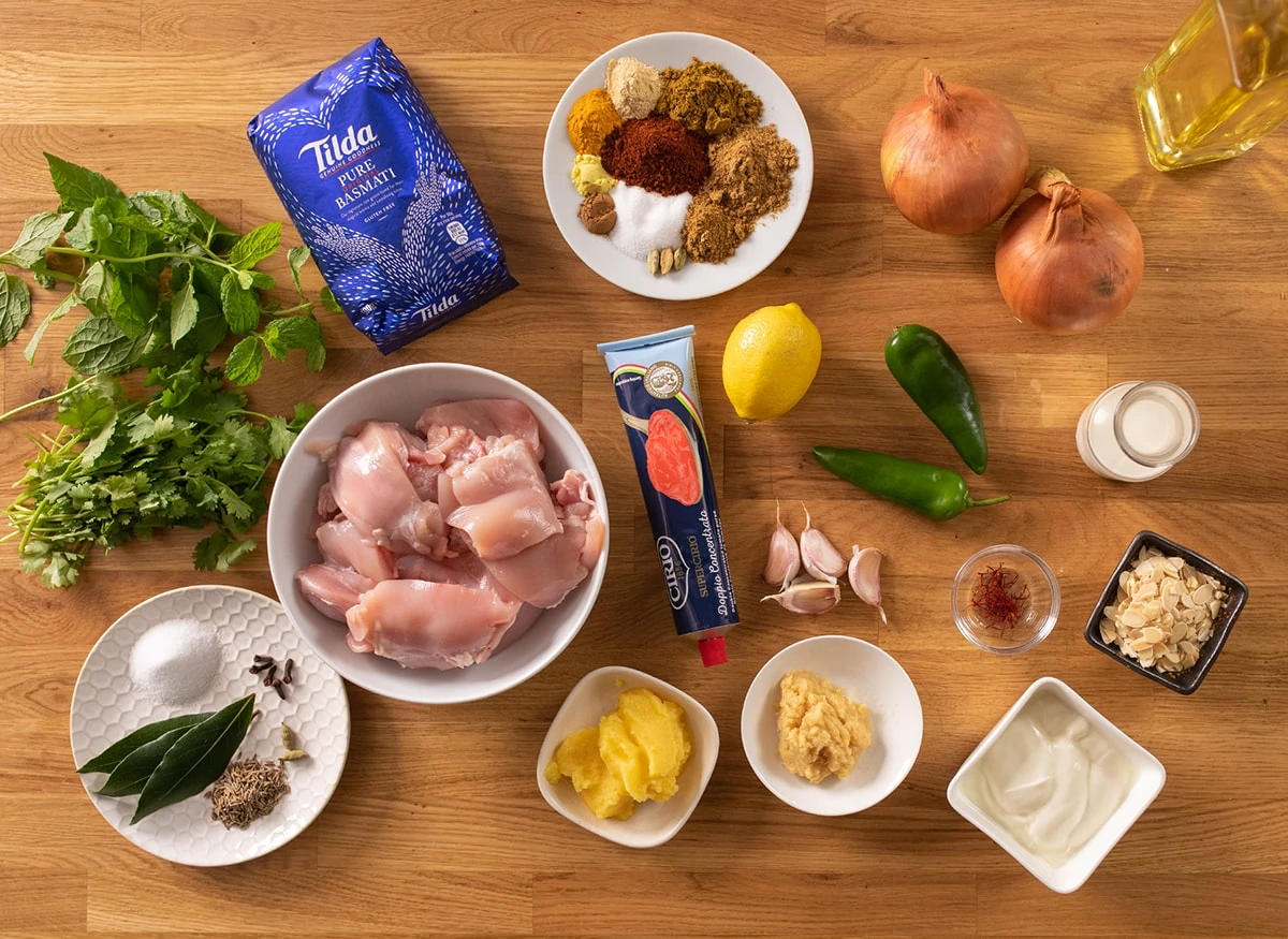 Ingredients for chicken biryani on a wooden table