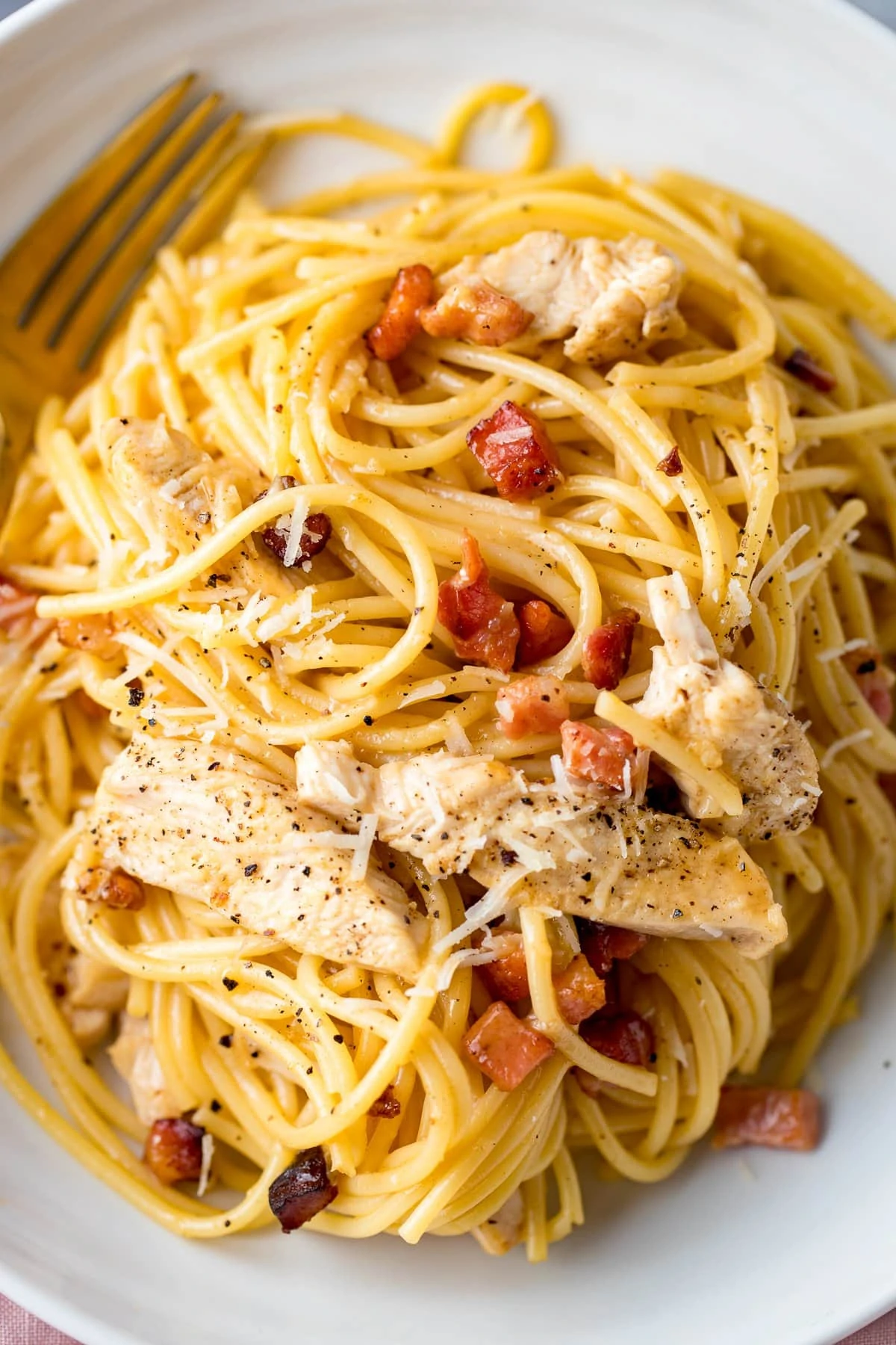 Close up of chicken carbonara in a white bowl