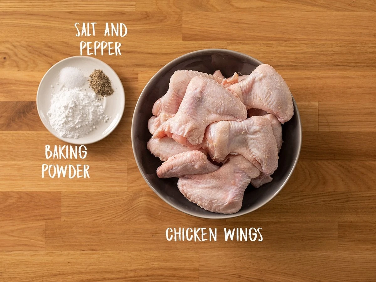 Ingredients for crispy chicken wings on a wooden table
