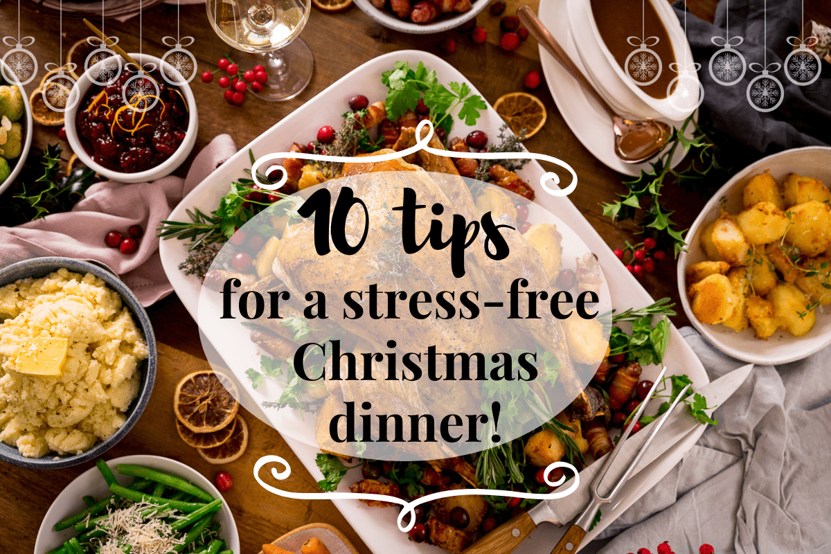 Wide Infographic showing text for 10 tips for a stress-free Christmas dinner on the background of a Christmas dinner table filled with food.
