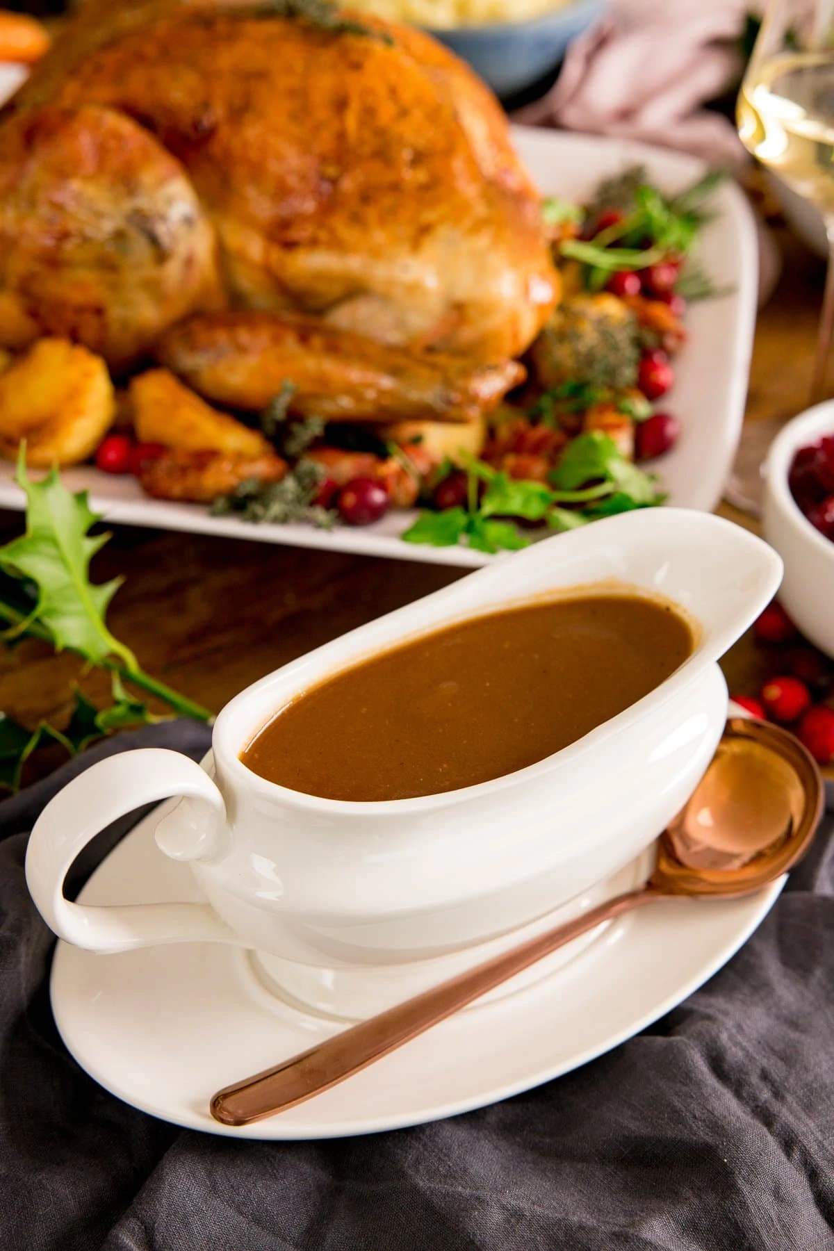 Christmas gravy in a white gravy boat with a roast turkey in the background