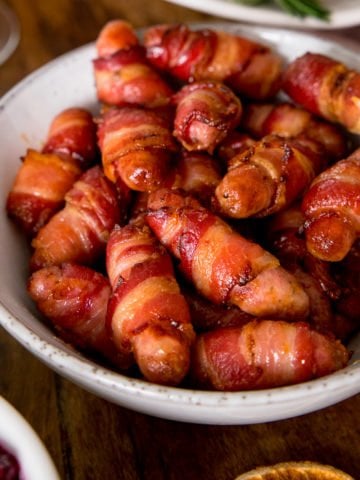 Sausages wrapped in bacon in a white bowl