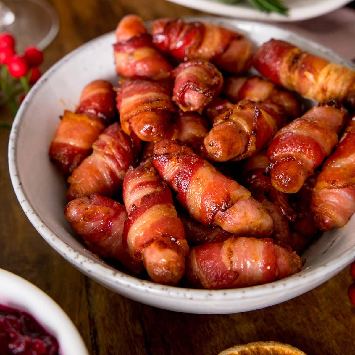 Sausages wrapped in bacon in a white bowl