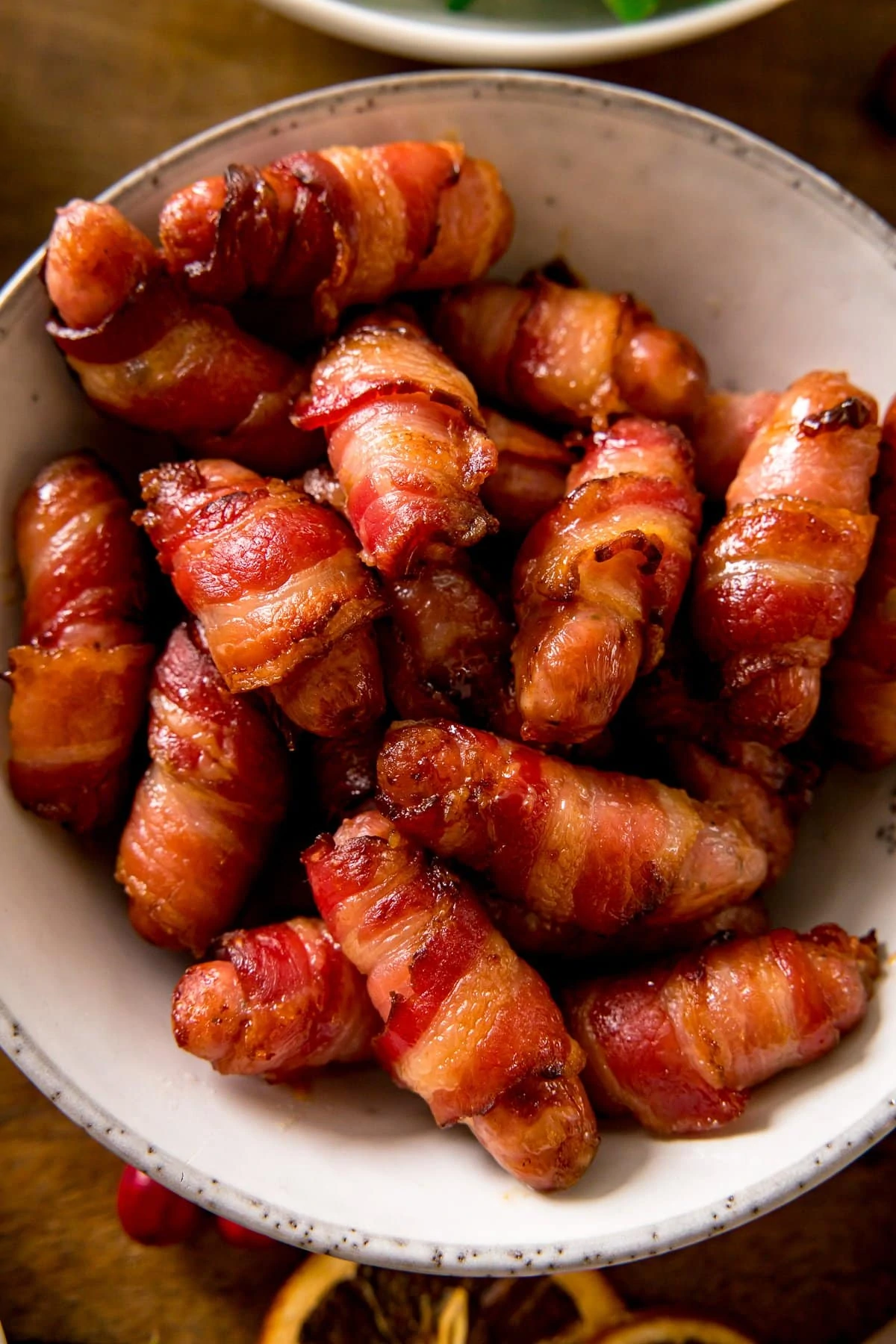 Close up of bacon-wrapped sausages in a white bowl