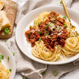 leftover turkey bolognese on a white plate with spaghetti