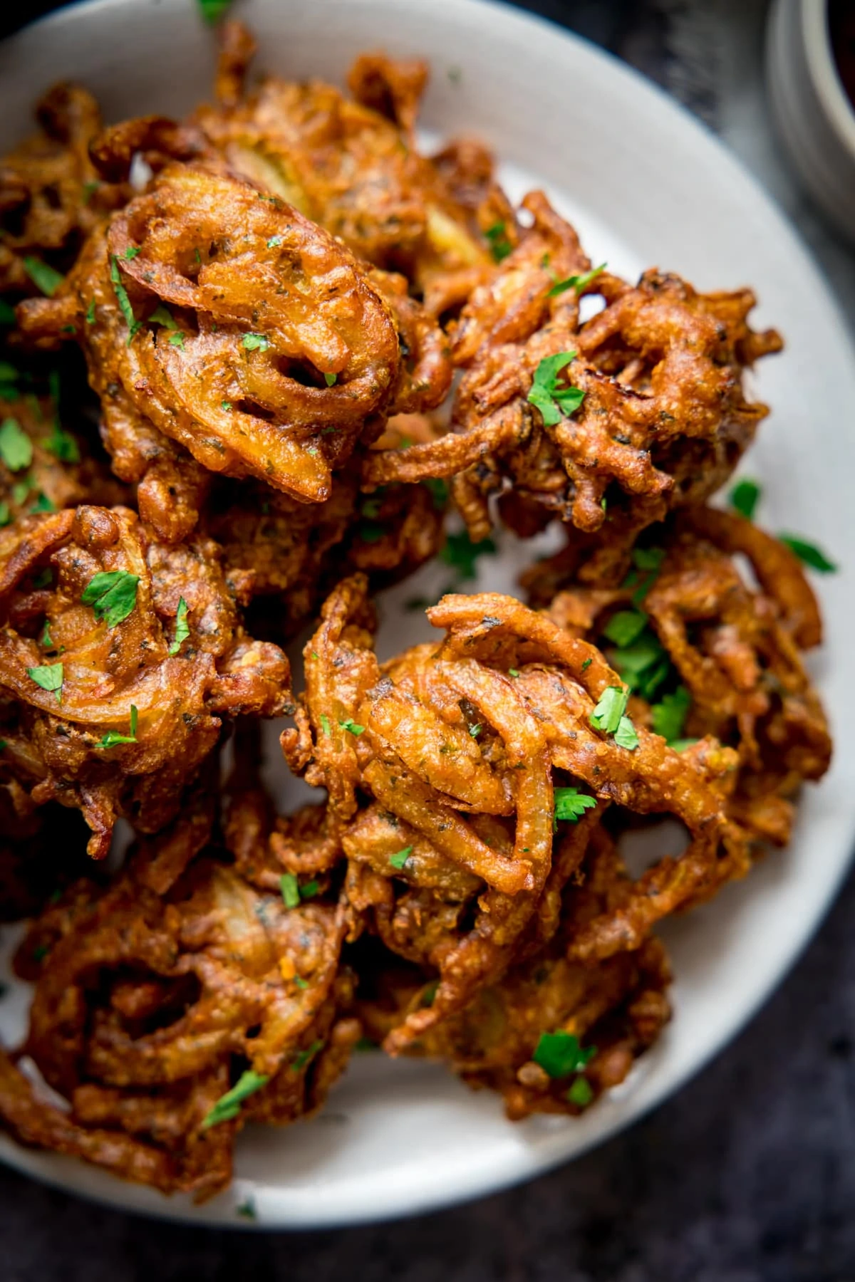 Overhead of Onion bhajis on a white plate.