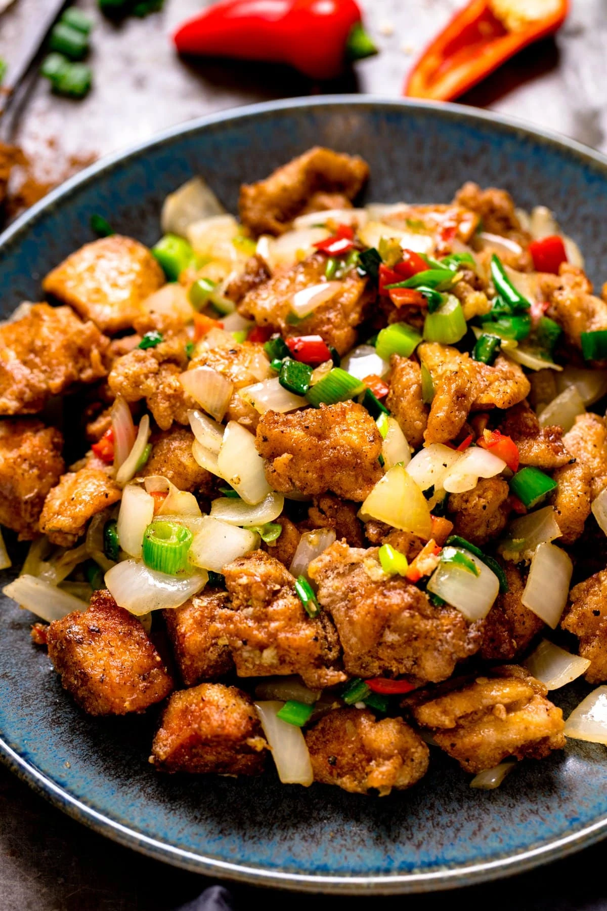salt and pepper chicken on a plate with ingredients in the background
