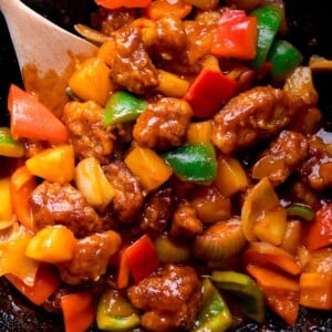 sweet and sour pork with peppers in a wok