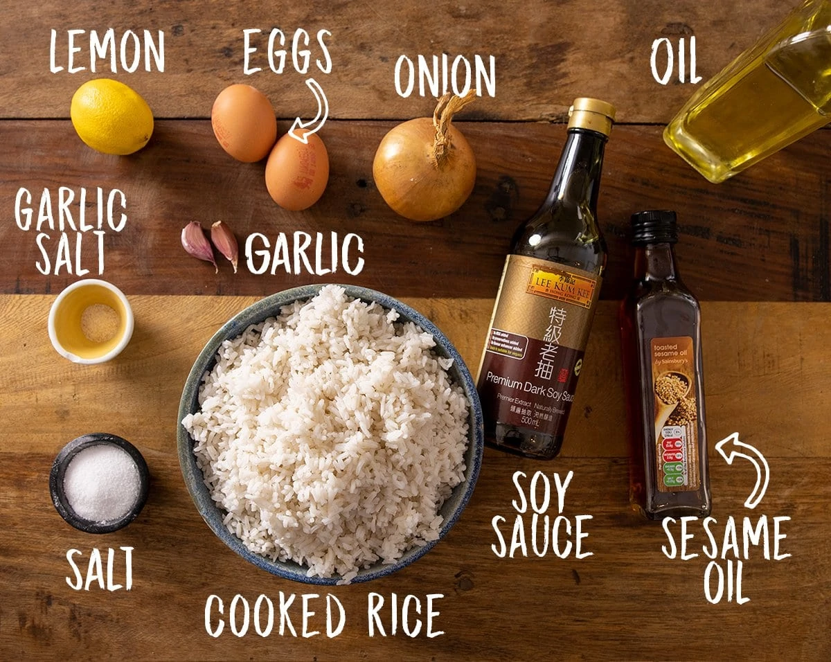 Ingredients for egg fried rice on a wooden table.