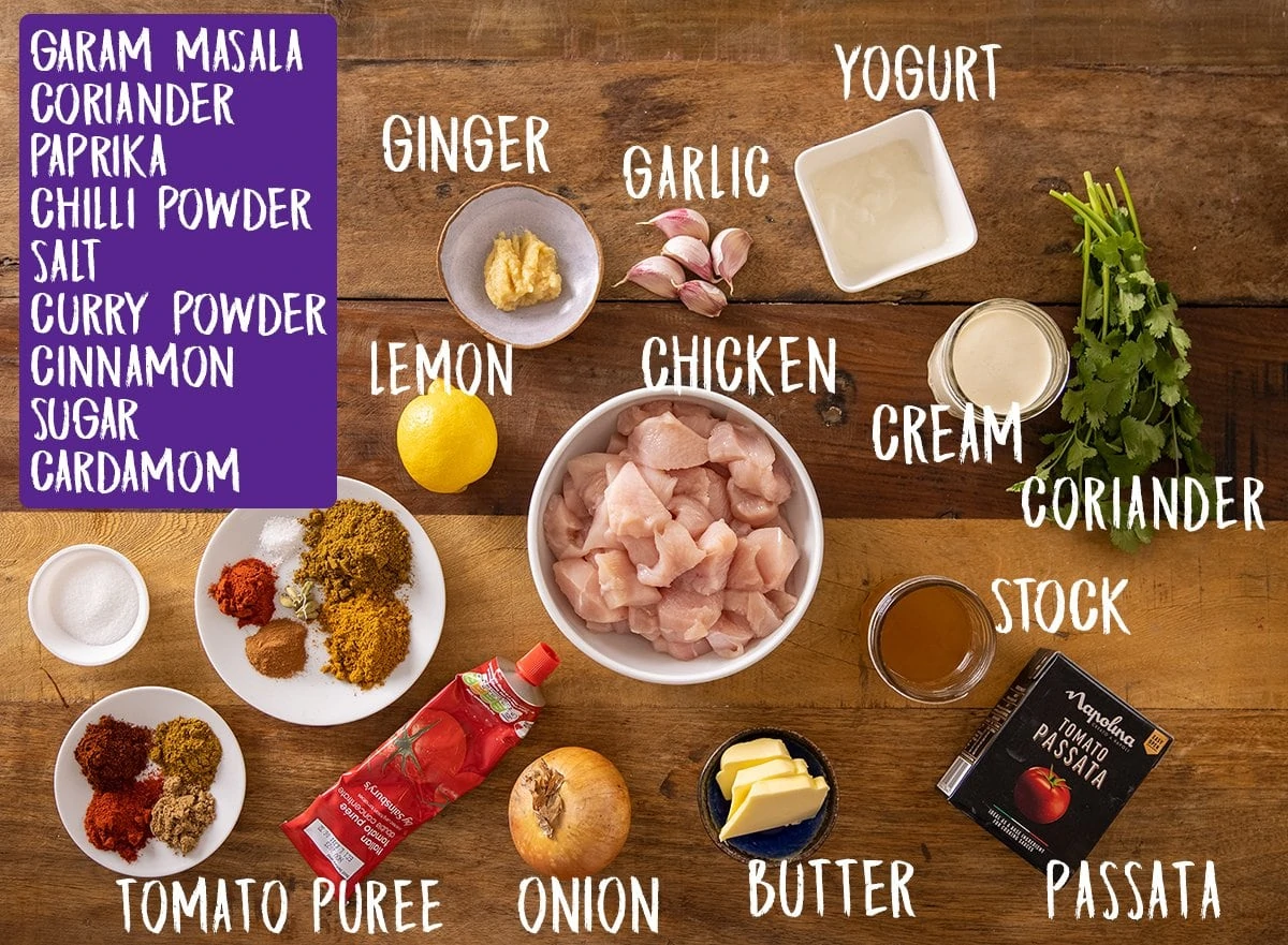 Ingredients for butter chicken curry on a wooden table