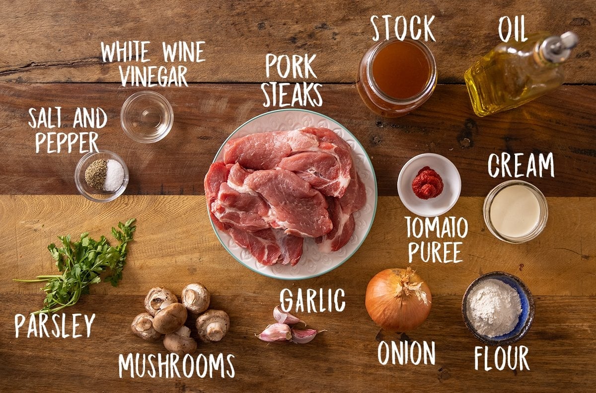 Ingredients for smothered pork on a wooden table.