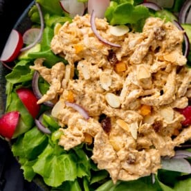 Coronation chicken on a bed of salad, topped with flaked almonds