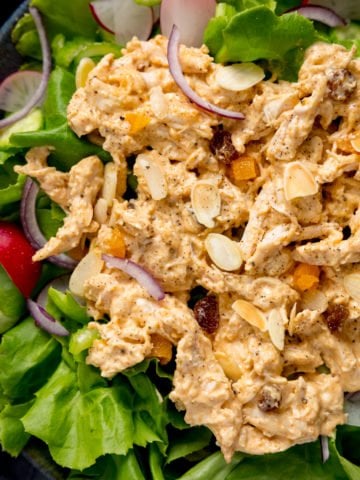 Coronation chicken on a bed of salad, topped with flaked almonds