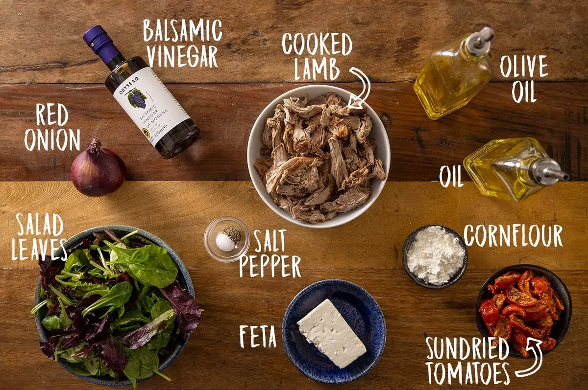 Overhead photo of ingredients for a lamb salad on a wooden table.