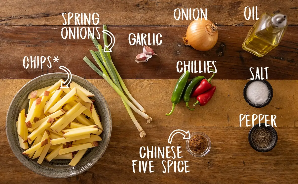 Labelled ingredients for making salt and pepper chips on a wooden board.