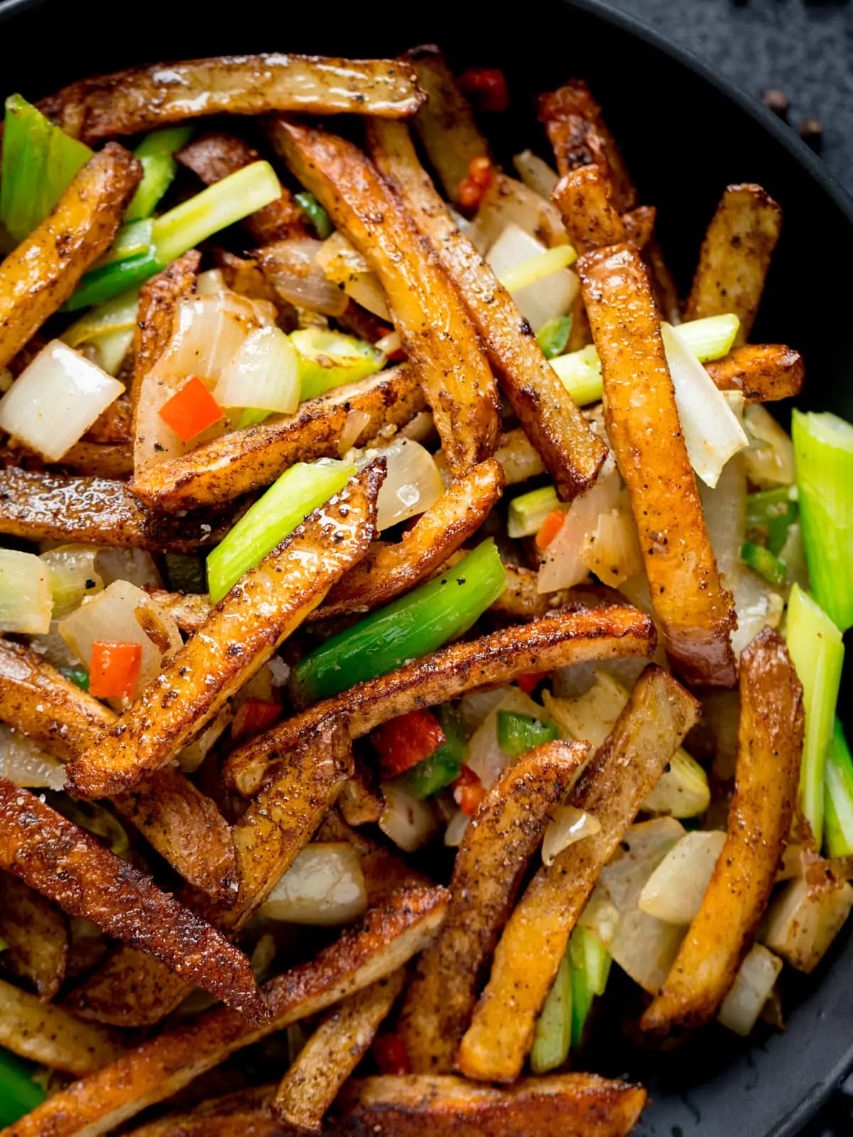 Close up overhead image of a black bowl filled with Salt and Pepper Chips.