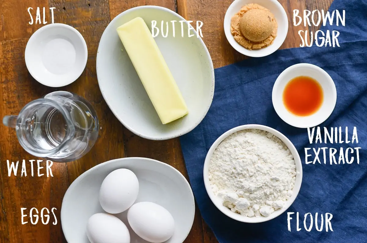 Overhead photo of ingredients for churros on a wooden board with a blue cloth.