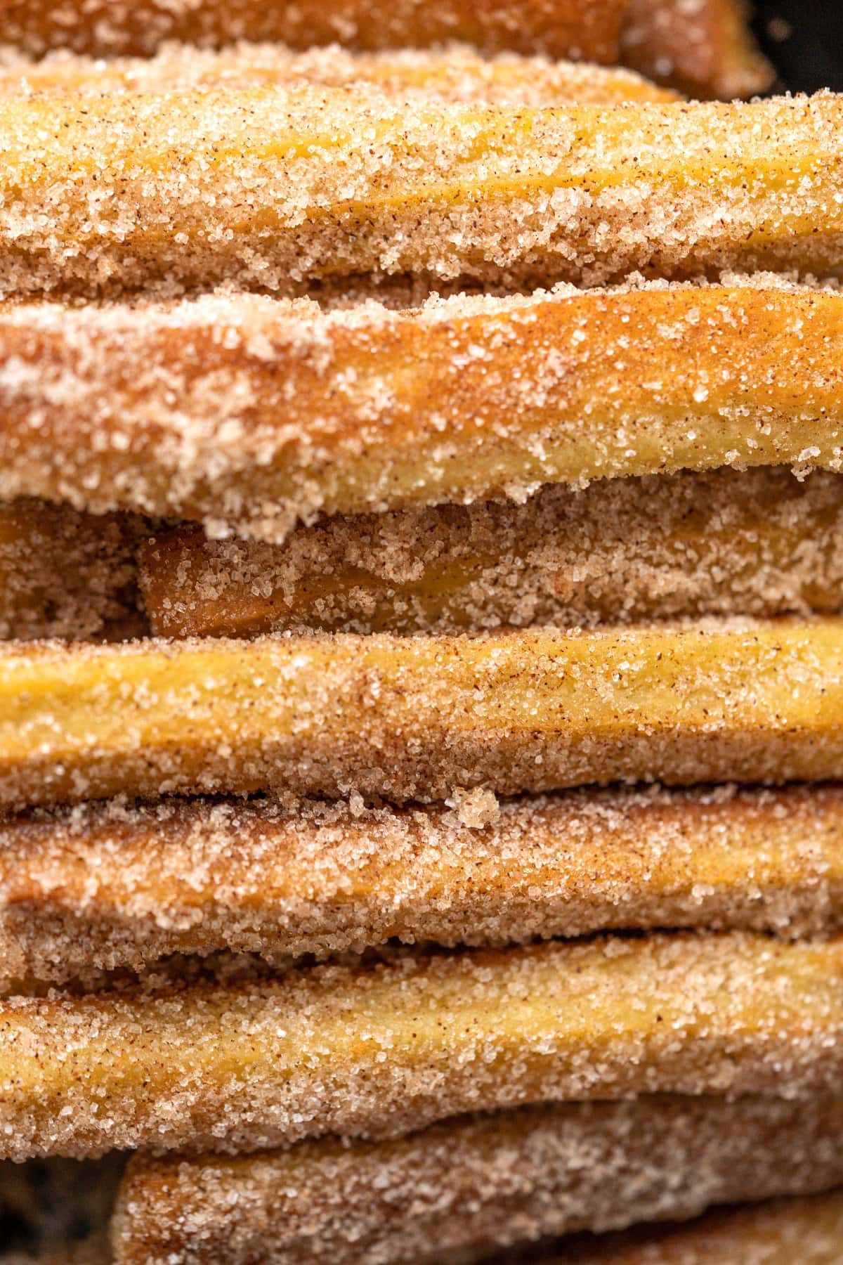 Close up picture of churros pilled up on top of each other.
