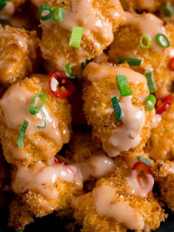 Close up of Crispy Cauliflower with bang bang sauce topped with chillies and spring onions