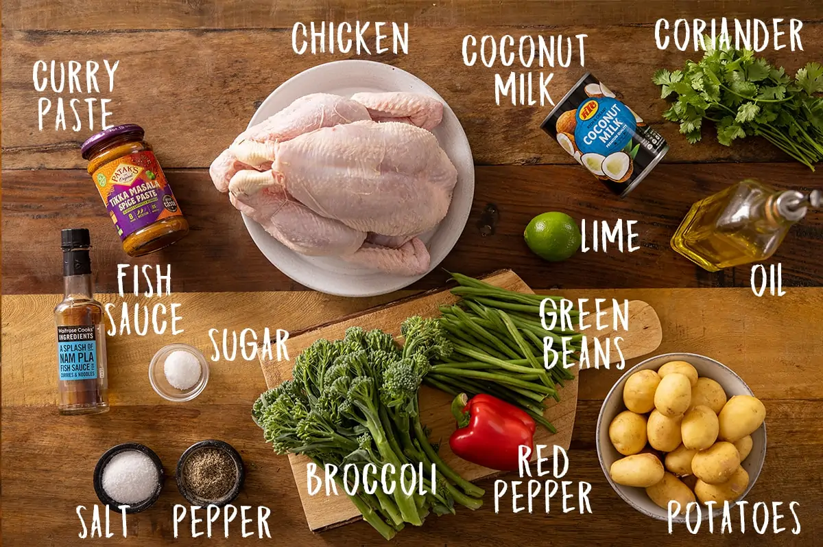 Ingredients for curry roast chicken on a wooden table.