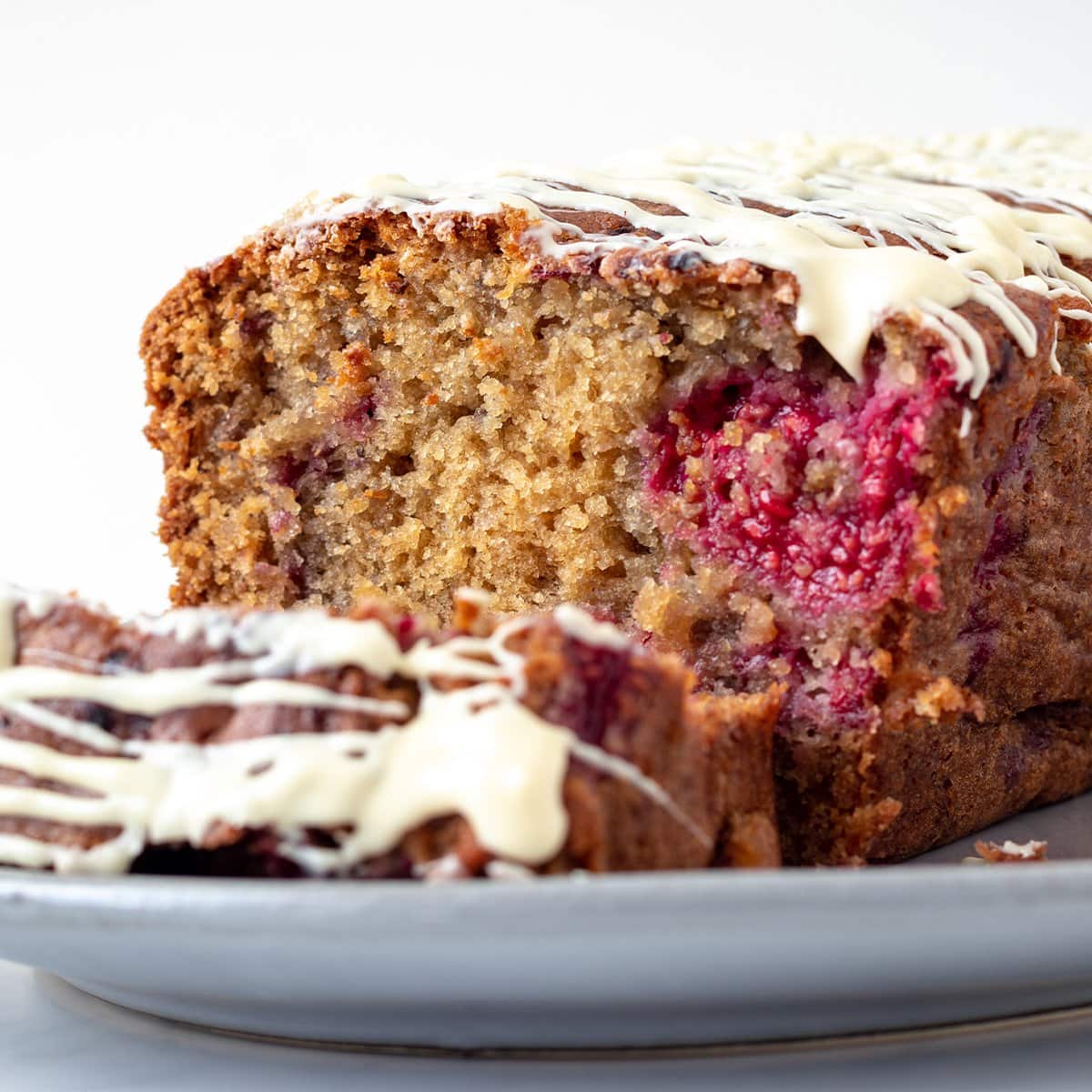 A close up picture of a raspberry and white chocolate cake showing the internal fluffy texture of the cake.