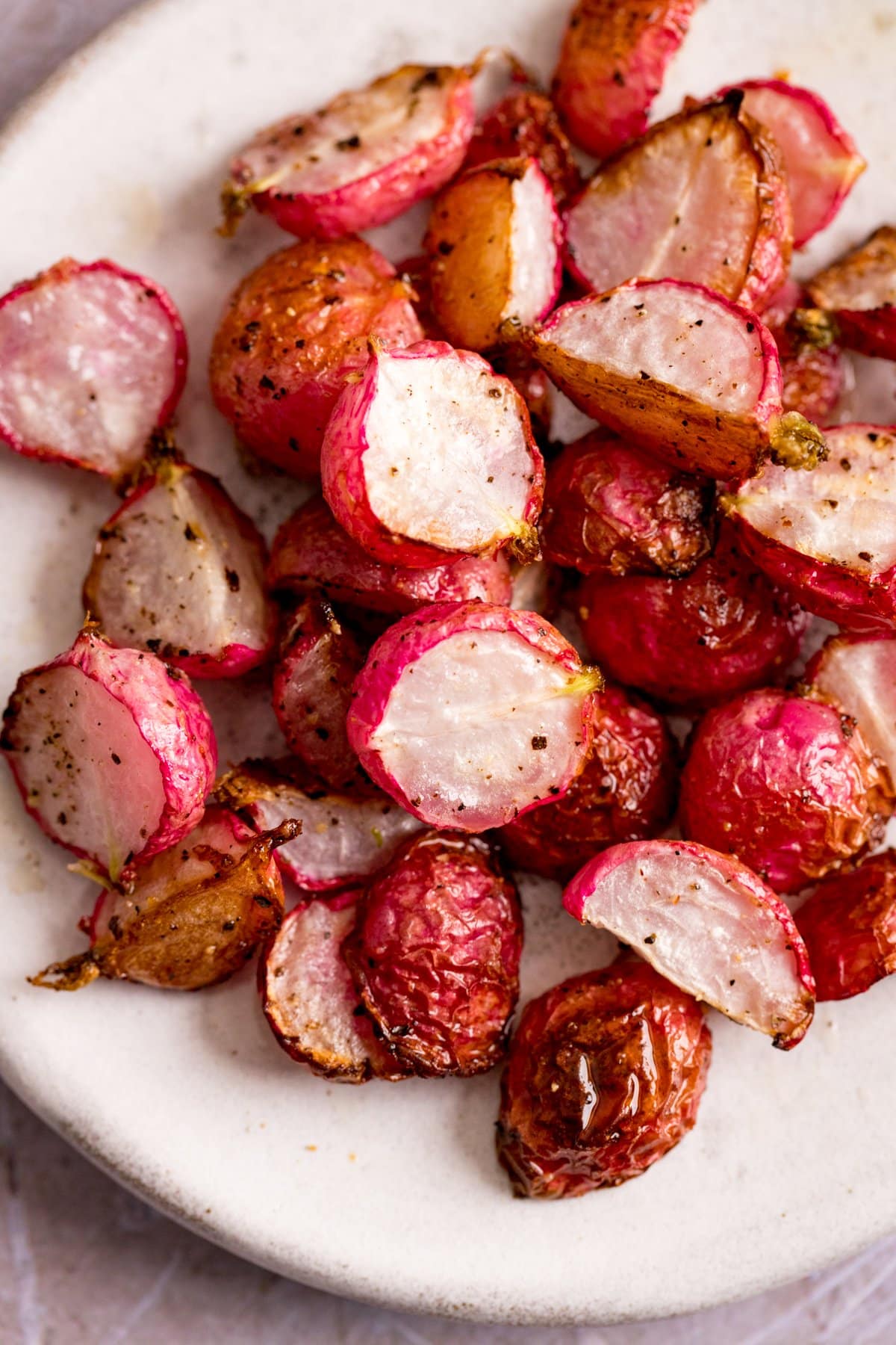 Roasted radishes on a white plate.