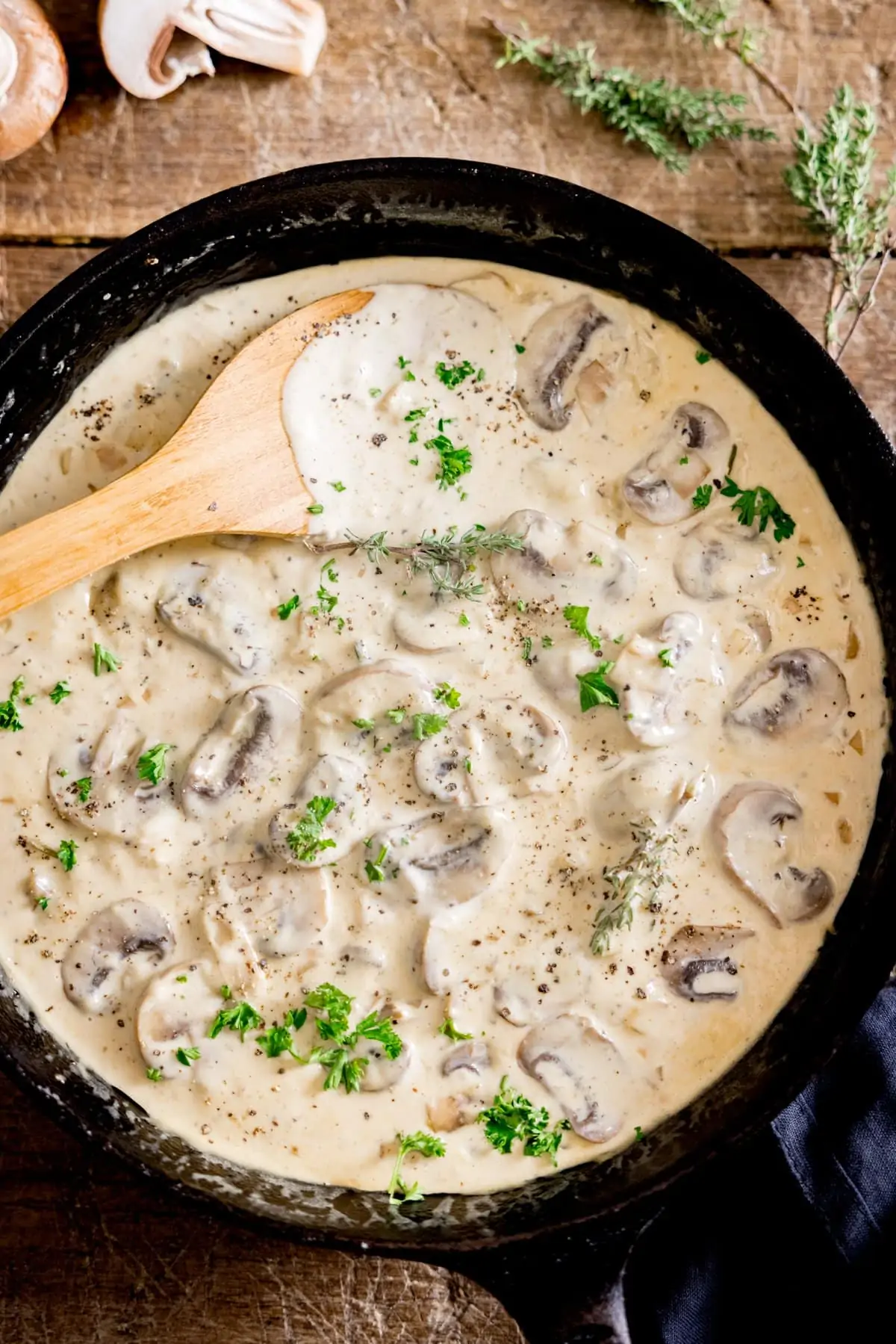 A pan of creamy mushroom sauce with a wooden spoon in it