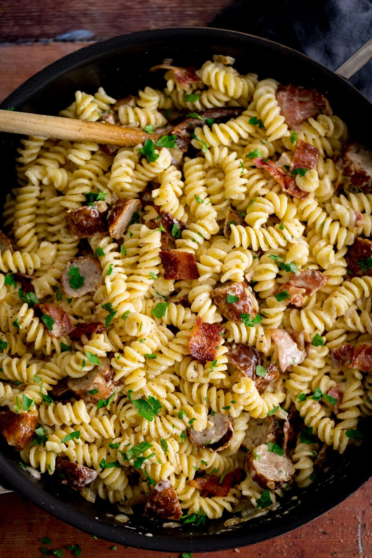 Pan filled with creamy pasta with sausage and bacon.