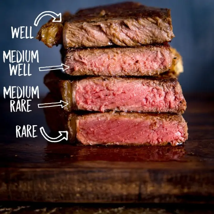 Square image of Four steaks on a wooden board, sliced open and piled on top of each other to show varying amounts of doneness. There is a label for each doneness level.