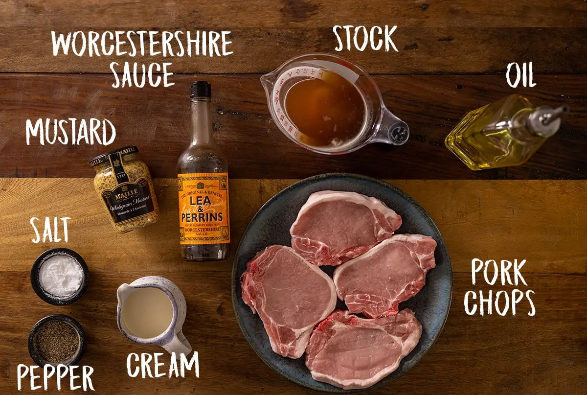 A wooden table full of the ingredients for Pork Chops with Creamy Mustard Sauce