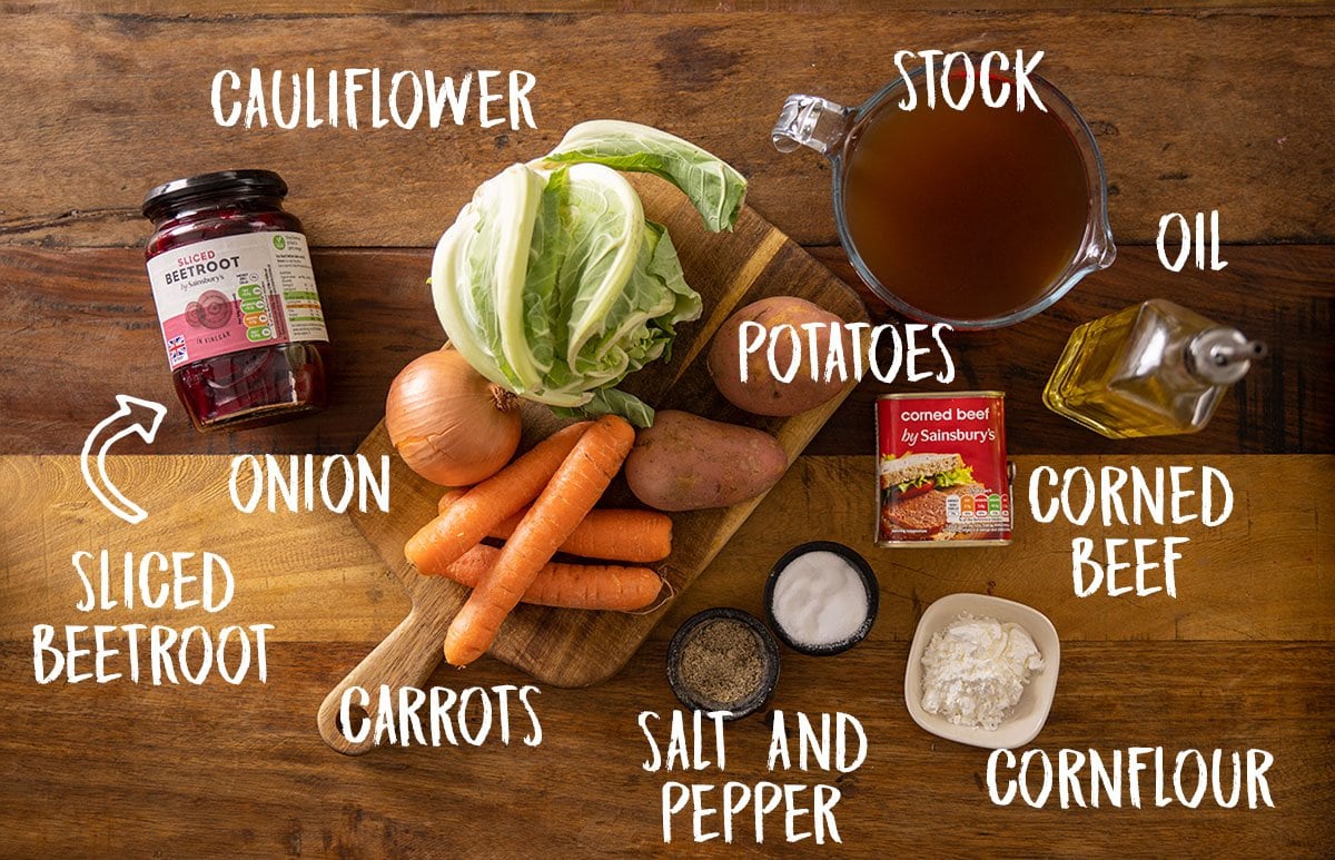 Ingredients for corned beef hash soup on a wooden board.