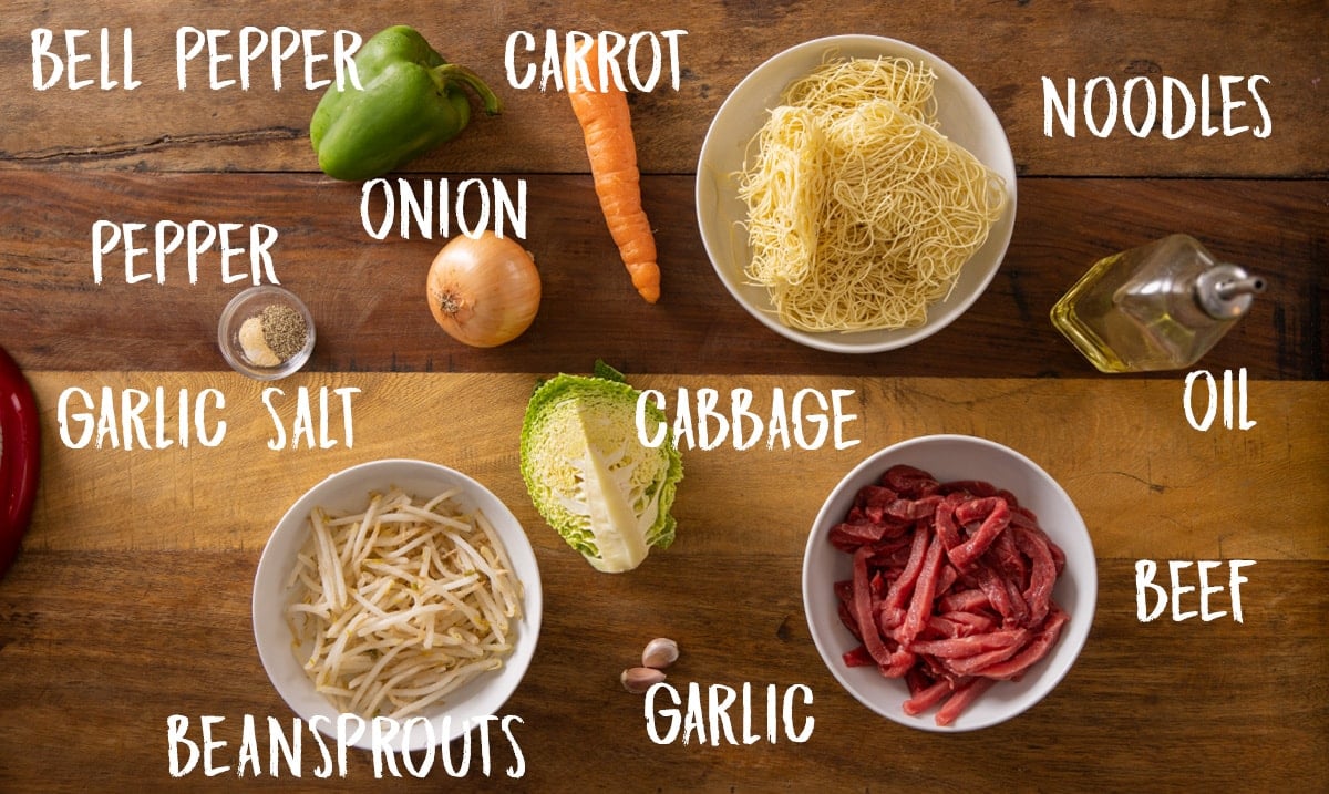 Ingredients for a beef stir fry on a wooden table.