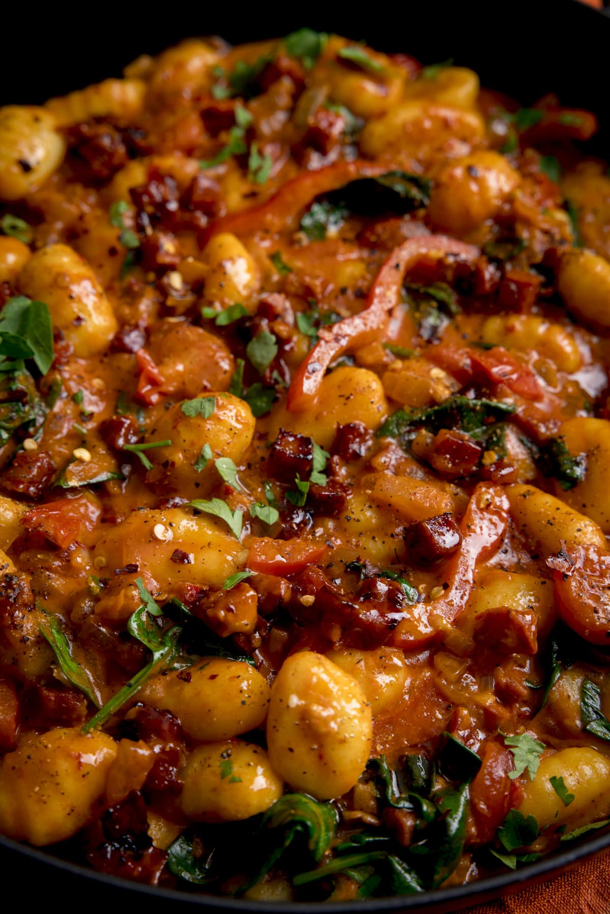 Close up of gnocchi with chorizo and red pepper in harissa coconut sauce.