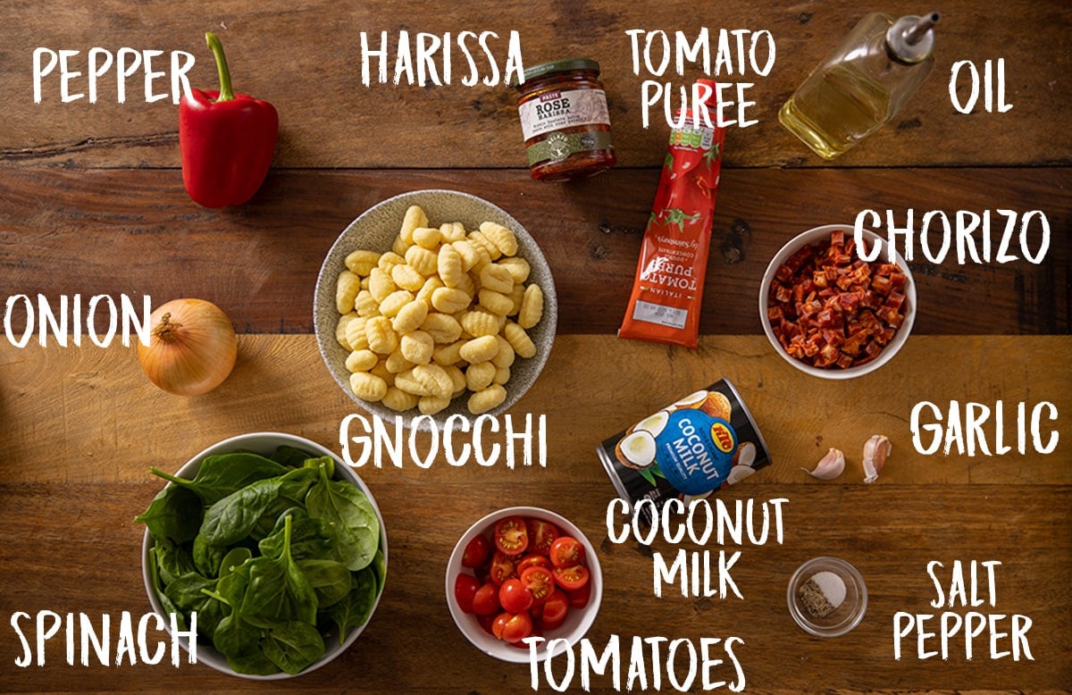 Ingredients for gnocchi with creamy harissa sauce on a wooden table.