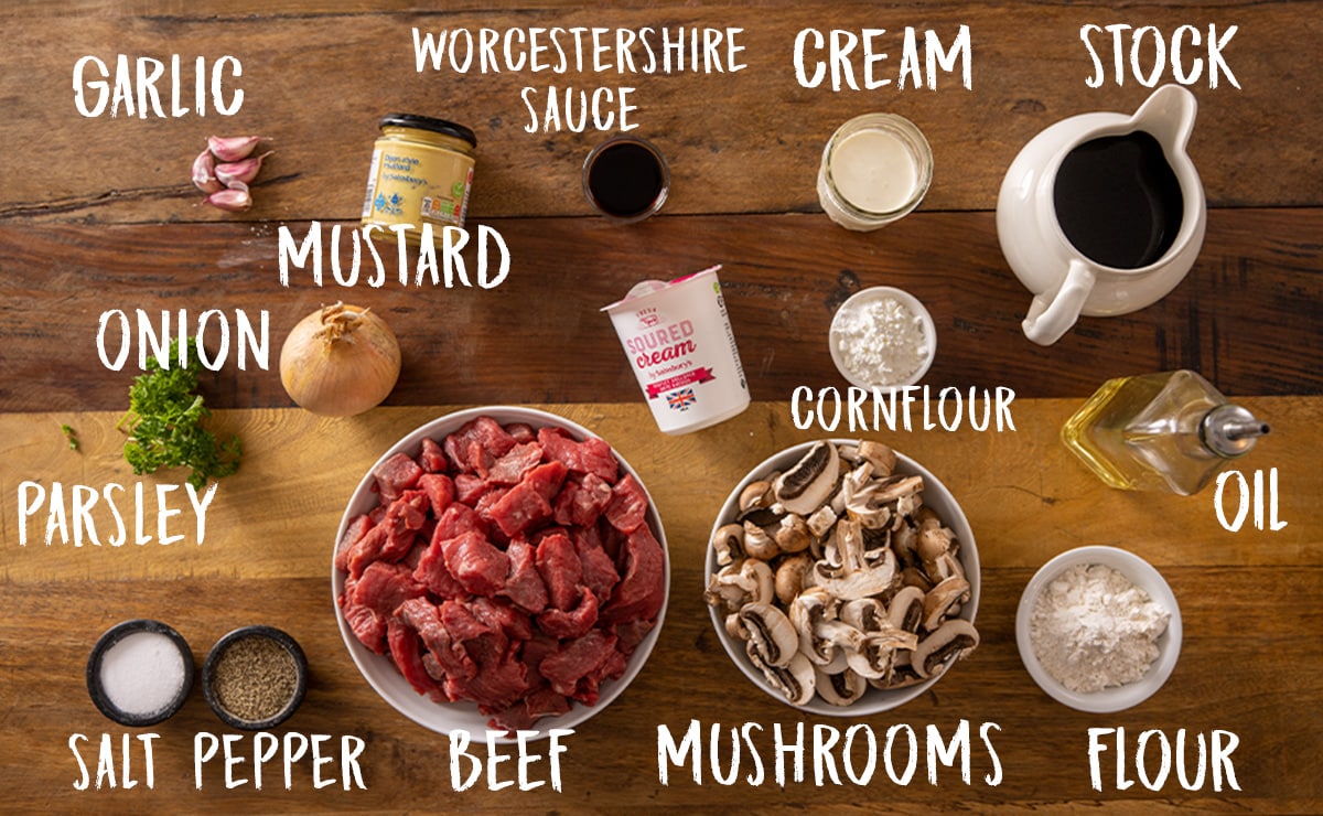 Ingredients for slow cooker beef stroganoff on a wooden table