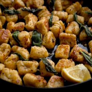 Close up of gnocchi with brown butter and sage in a pan with lemon