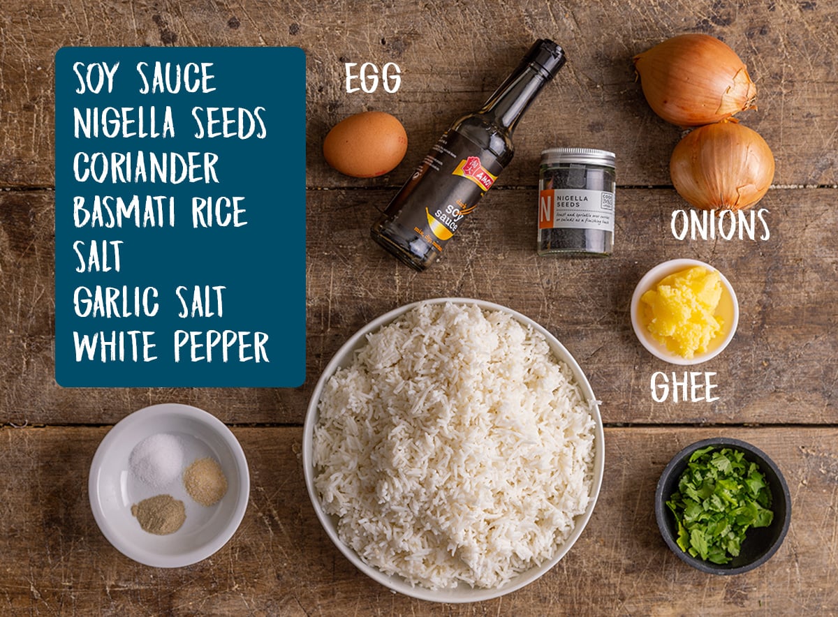 Ingredients for onion fried rice on a wooden board.