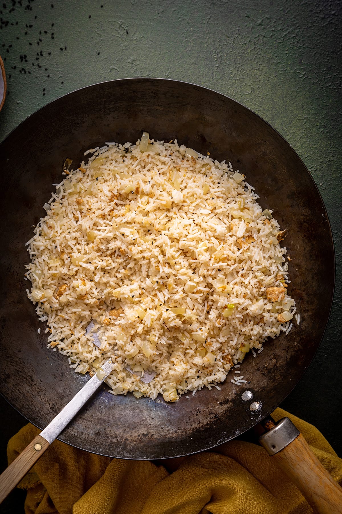 Zwiebel gebratener Reis in einem Wok mit Metallspatel.