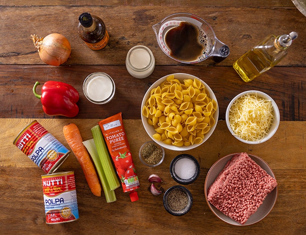 Ingredients for one pan bolognese pasta on a wooden table.
