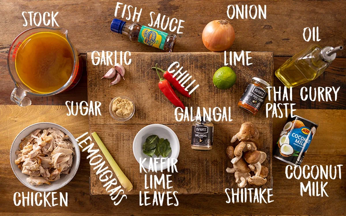 Ingredients for Tom Kha Gai Soup on a wooden board.