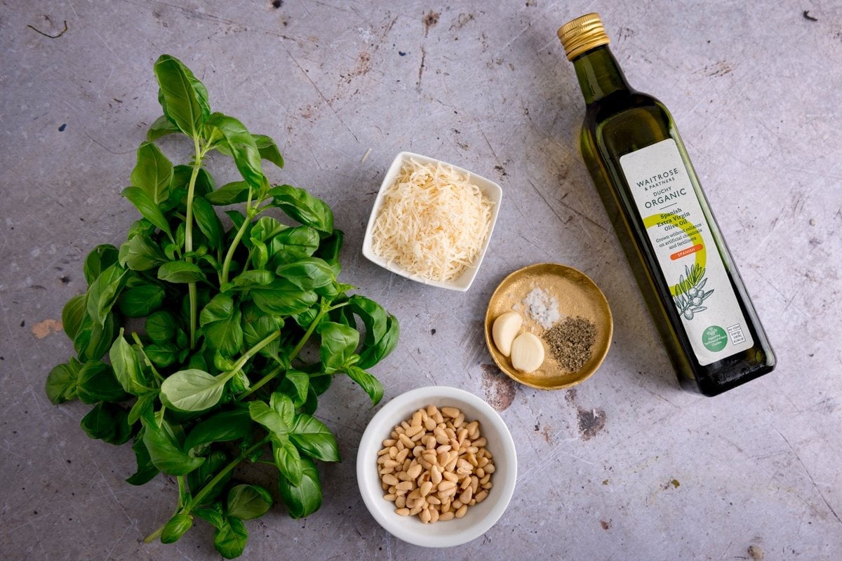 Ingredients for homemade pesto on a light grey surface