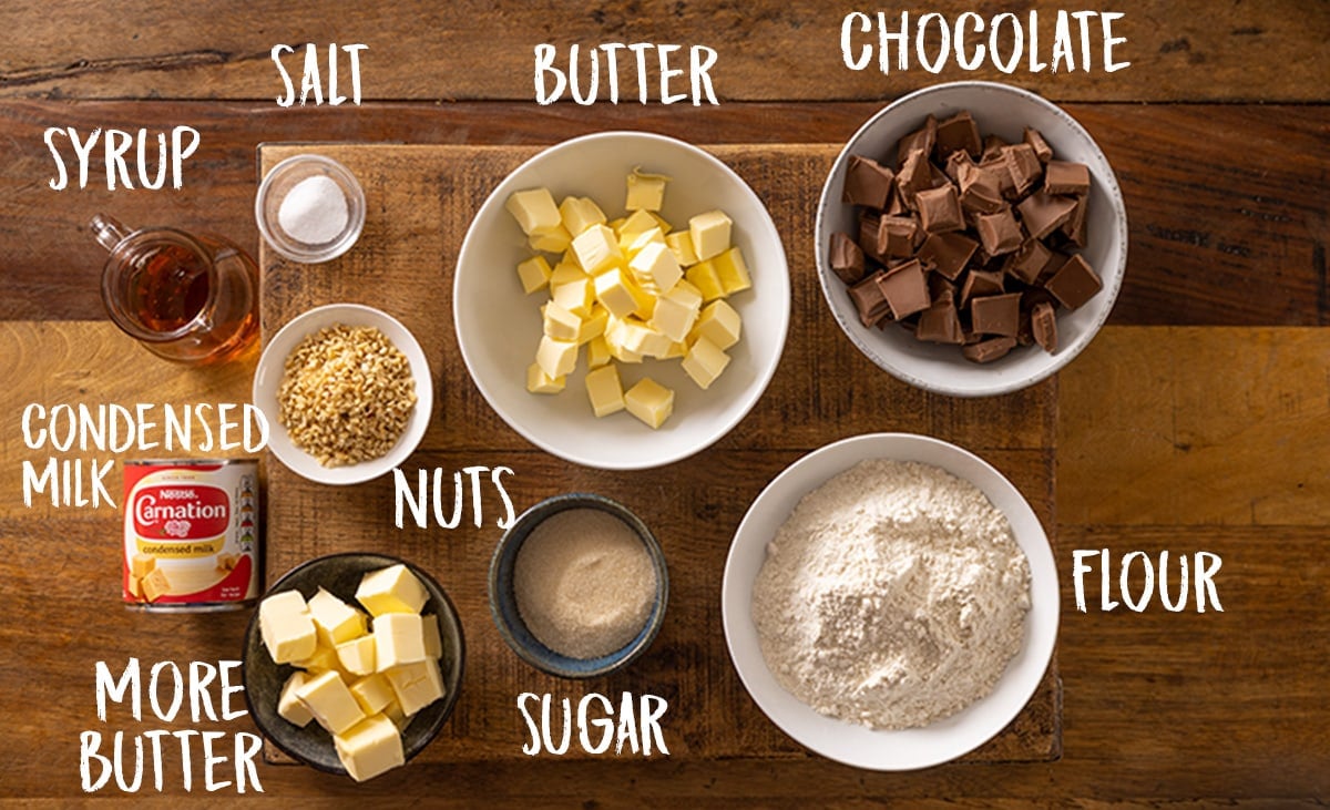 Ingredients for salted caramel millionaire's shortbread on a wooden table.